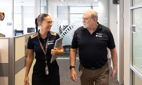 Two NIAA staff members walking down a corridor