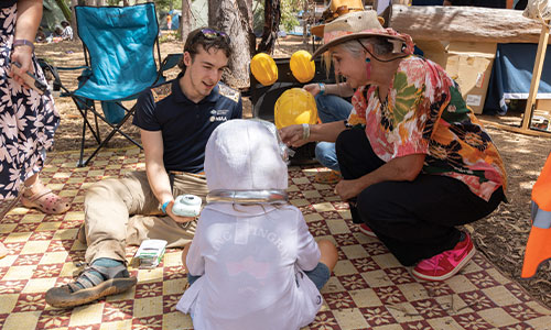 Jody Broun with NIAA staff member and a child at the Garma festival