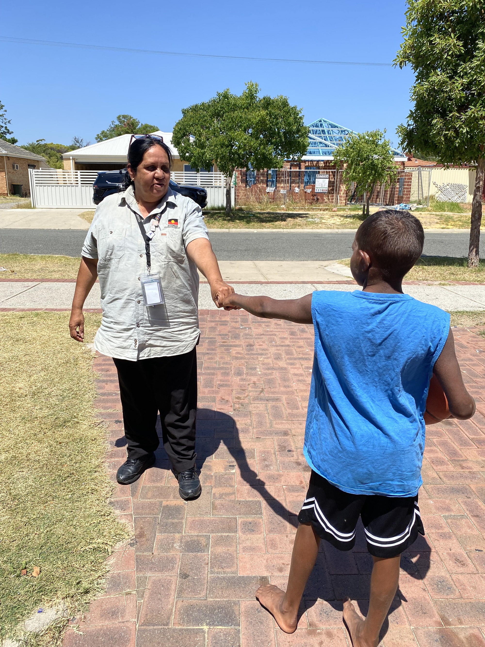 A woman fist-bumps a young boy