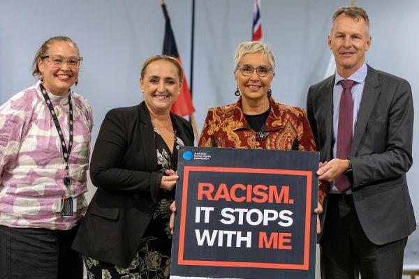 NIAA Group Manager Julie-Ann Guivarra standing alongside Deputy CEO Letitia Hope, CEO Jody Broun and Deputy CEO Blair Exell holding a black sign board with the words ‘Racism. It Stops With Me’
