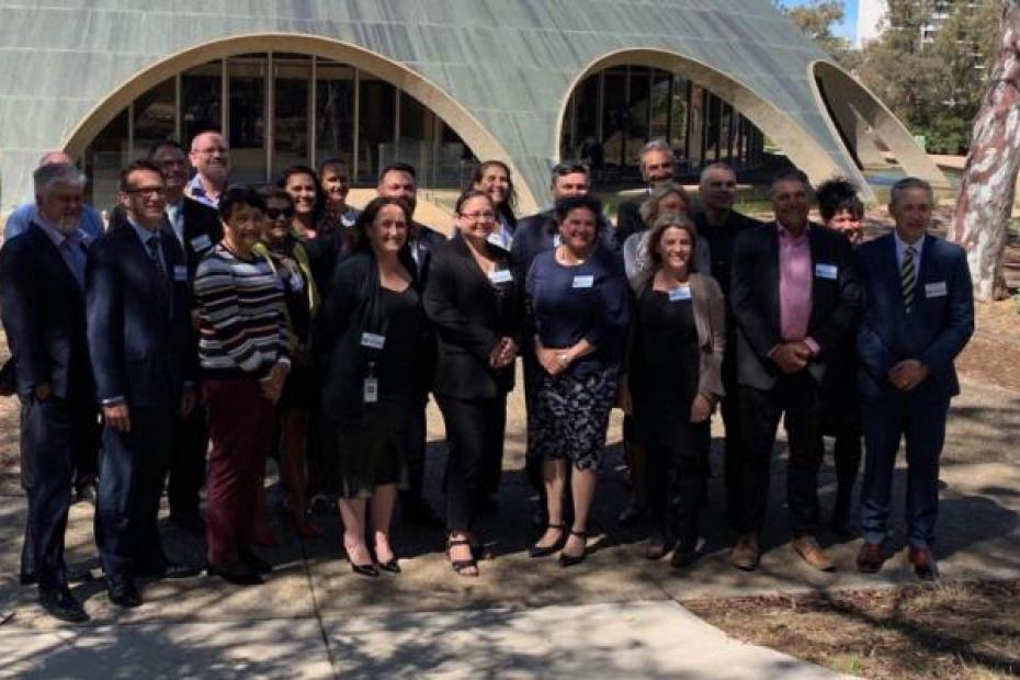 Twenty-three Indigenous leaders from the public services across Australia and New Zealand pose for a picture in front of the Shine Dome in Canberra, Australia