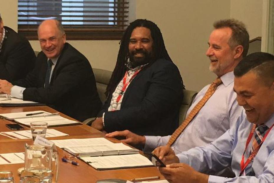 A meeting of the IAC with five people present at a desk.