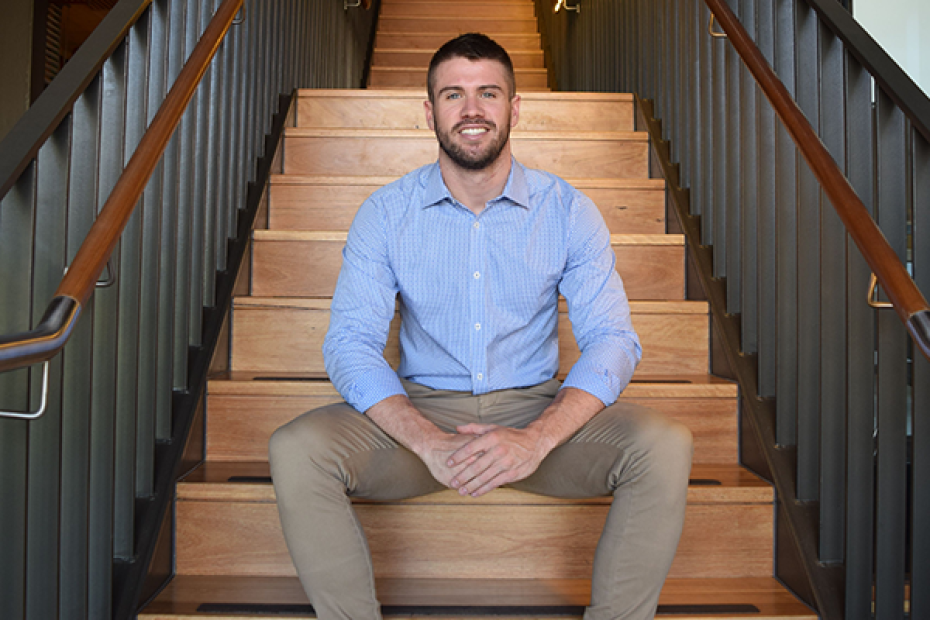 Image of Peter Honeyman smiling, sitting on a staircase