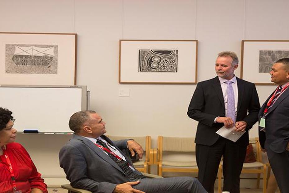 Four people, three men and one woman, having a discussion related to the Indigenous Advisory Council