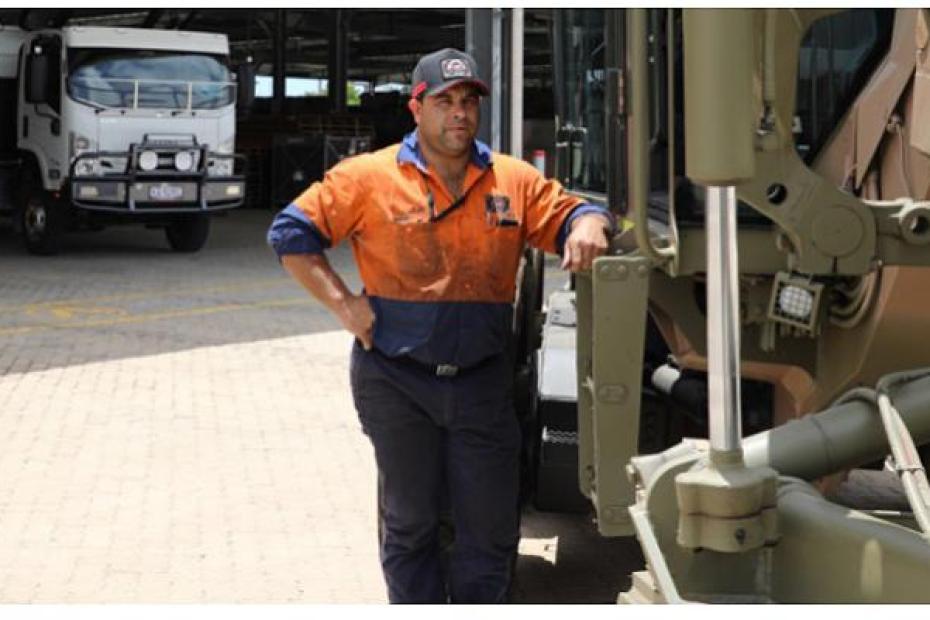 Luke Murr, owner of CAL Diesel, inspecting an army grader, with CAL Diesel mobile workshop in the background.