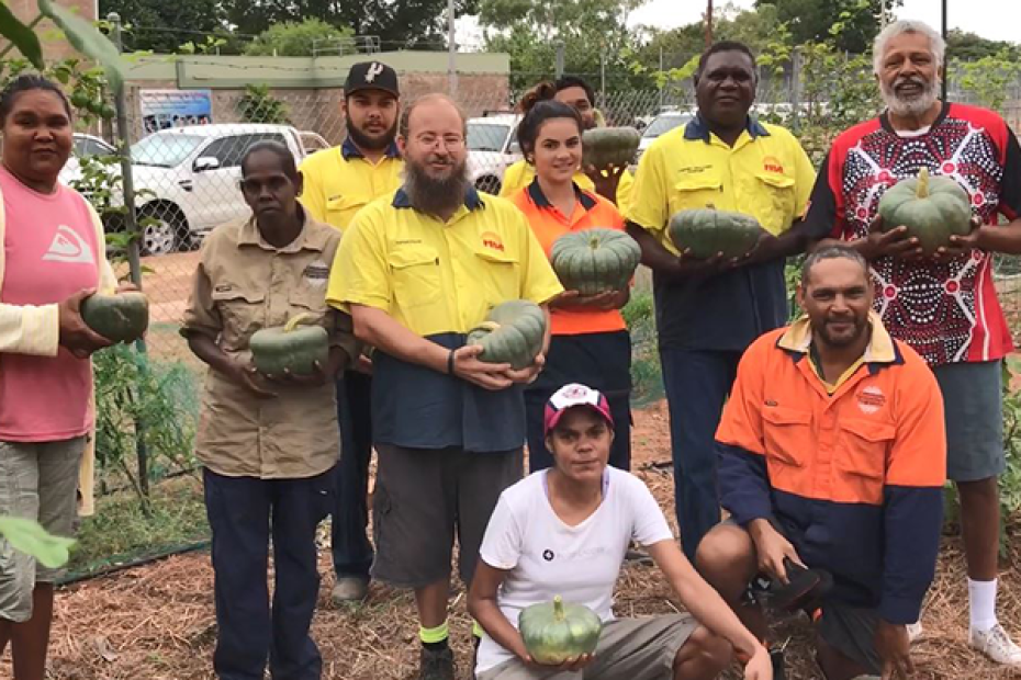 Image of group of indigenous workers holding pumpkins